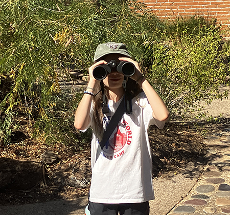 A camper uses binoculars